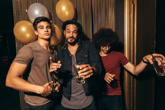 Portrait of group of young men having fun at nightclub