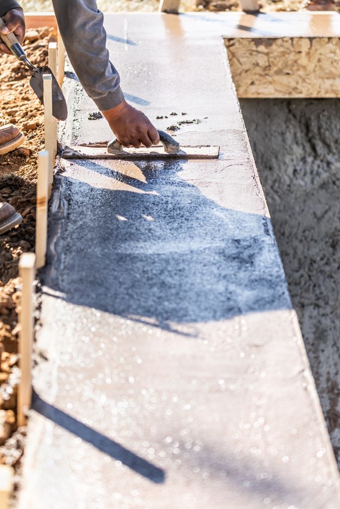 Construction Worker Using Wood Trowel On Wet Cement Forming Coping Around New Pool