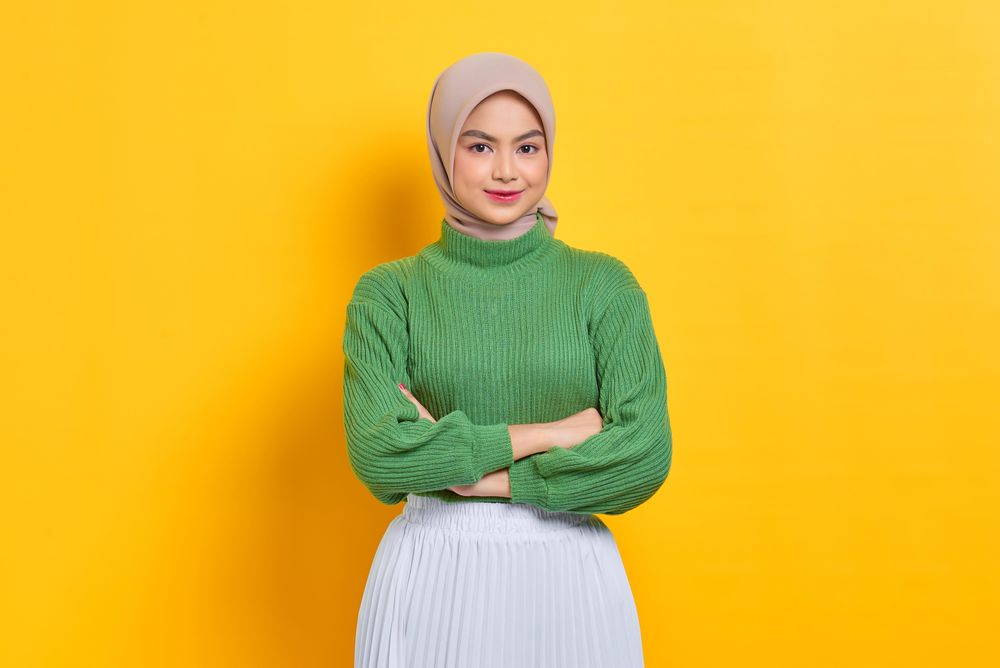 Smiling woman in headscarf with arms crossed