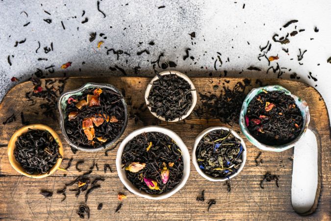 Top view of loose leaf tea varieties on wooden board