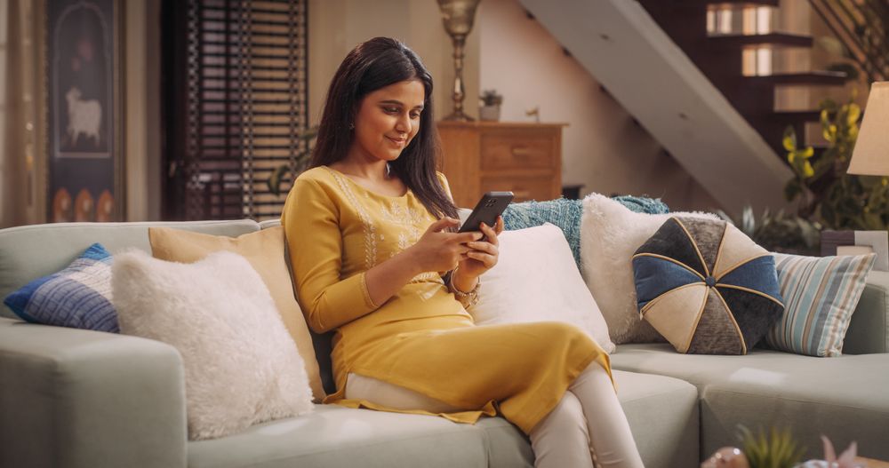 Stylish Woman Enthralled in Smartphone Use at Home