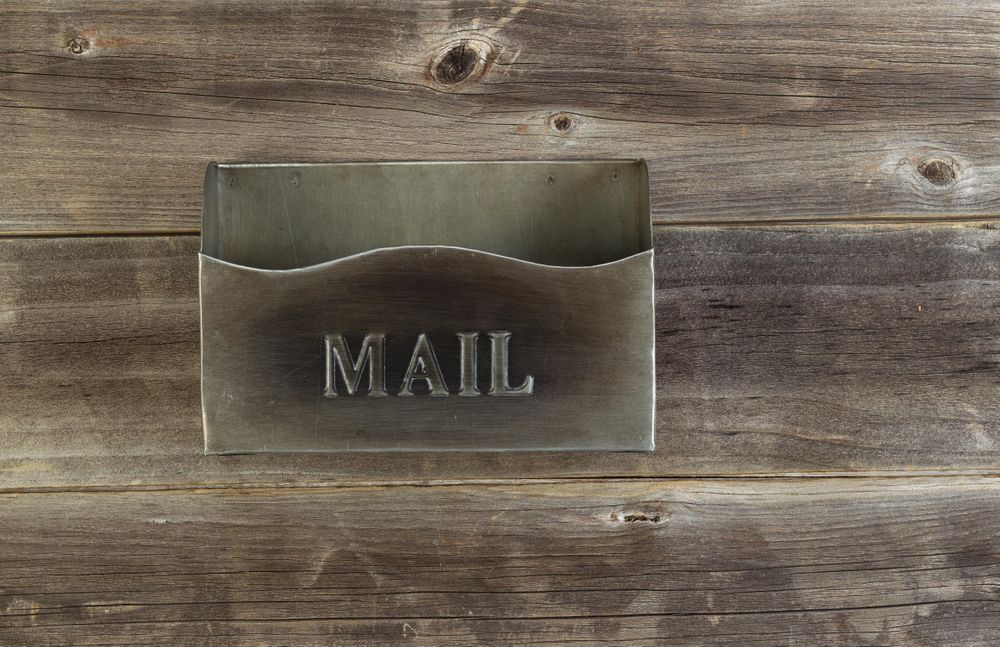 Empty old metal mailbox on weathered wood