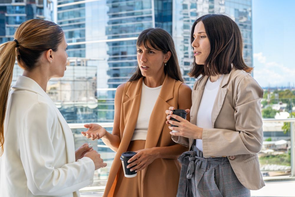 The female boss is informing her two employees that they need to focus on work rather than engaging in gossip.  One of them does not like her comment.