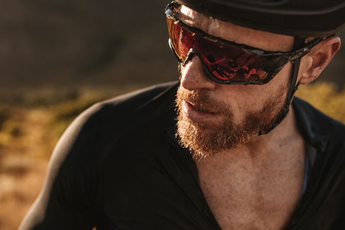 Male cyclist with sweat on his face looking away