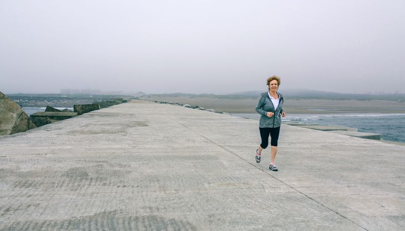 Older woman with headphones running