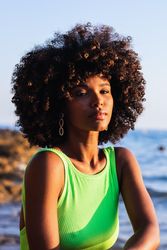 dreamy Black woman standing in sea during summer vacation