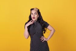 pin-up girl posing to the camera over yellow background.