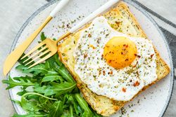 Delicious breakfast of fried eggs with toast and salad.