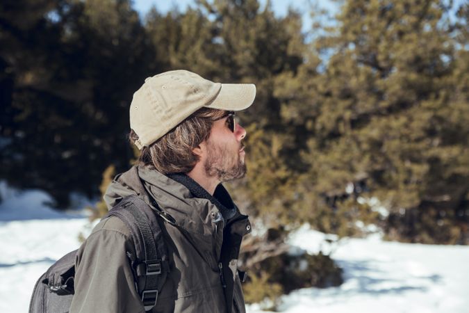Man between winter forest in sunny day
