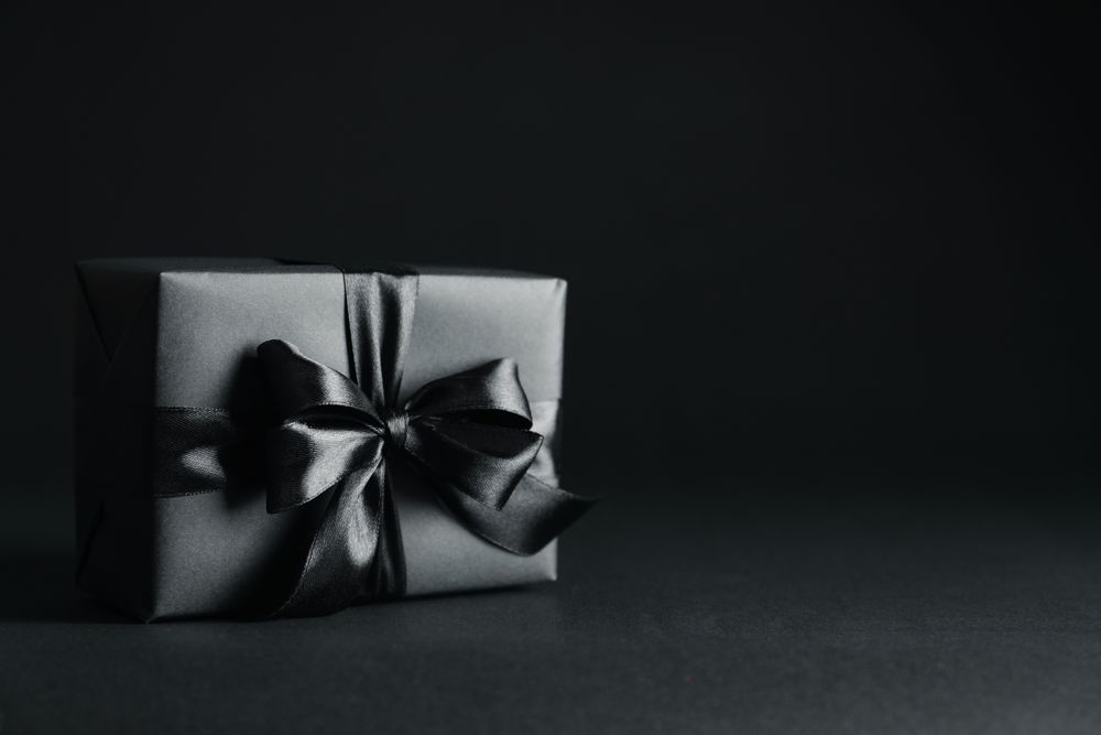 Gift box with dark bow on dark background