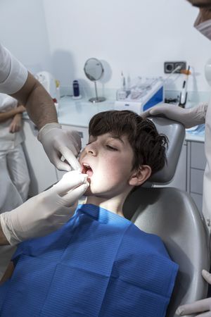 The doctor treats a tooth of little boy at dentist's clinic