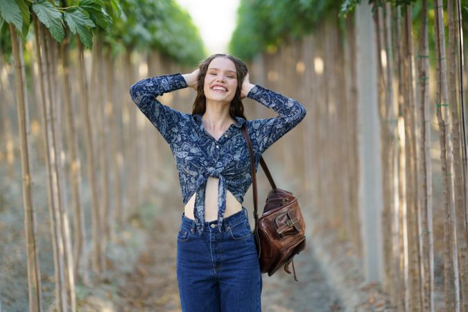 A Joyful Young Woman is Posing Happily in a Lush Vineyard Surrounded by Natures Beauty