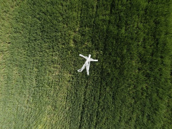 An aerial view of a man made of plastic garbage illustrates the concept of ecology and microplastics.
