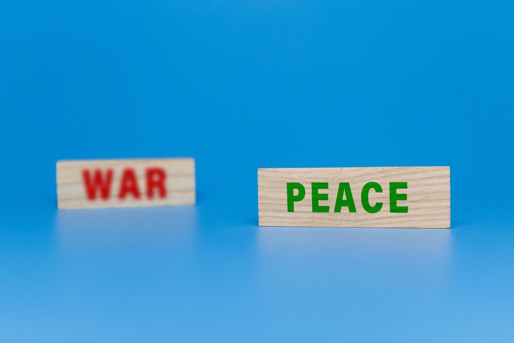 peace and war words symbol concept on wooden blocks isolated on blue background