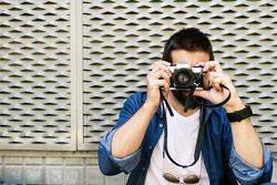Man in denim taking photo outside