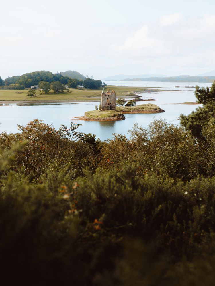 Ancient castle against hills on lake coast