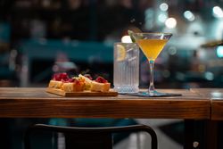 Elegant cocktail and appetizer platter in a stylish bar at night