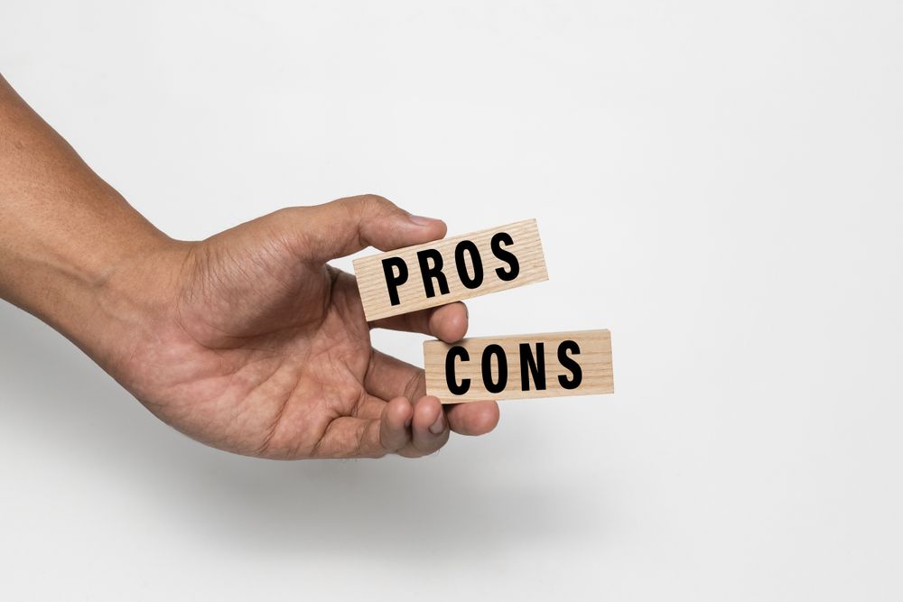 male hands holding pros and cons wooden blocks