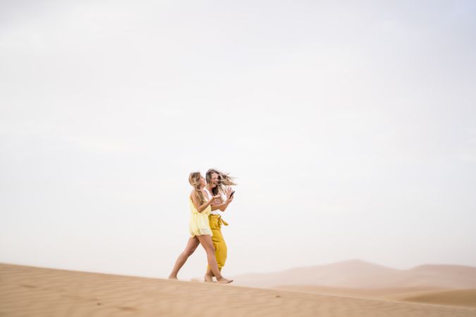 Happy women walking in the desert in desert