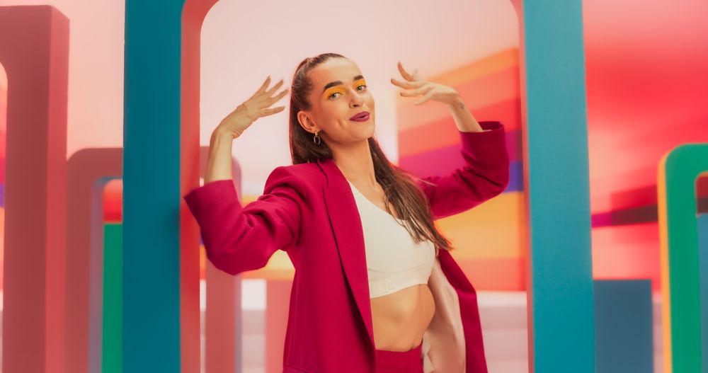 Medium Shot of an Woman in a Fashionable Outfit Moving her Hands Gracefully While Dancing and Looking at Camera. Female Dancer Performing Choreography in Spacious Bright Studio.