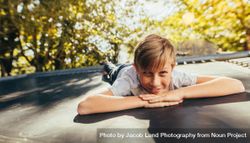 Little boy resting on trampoline after playing outdoors bxN6d5