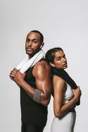 Fit couple standing with back against each other