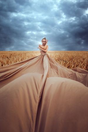 Woman in big brown dress posing in wheat field