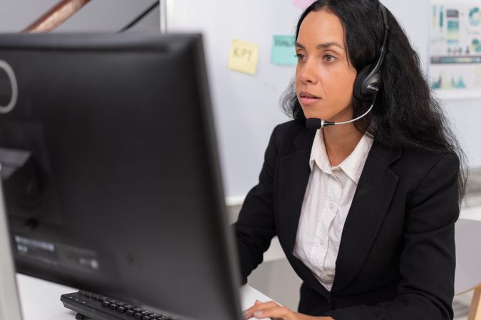 Latina employee working at desk to support customers in the office