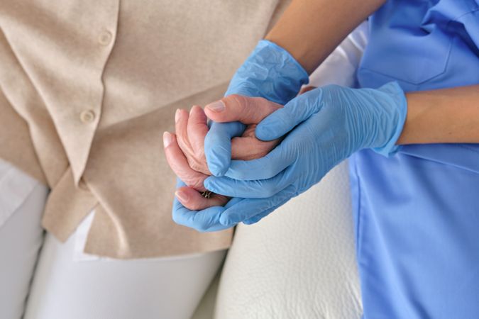 Crop doctor holding patient by hand during checkup