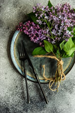 Spring table setting with lilacs on ceramic plate
