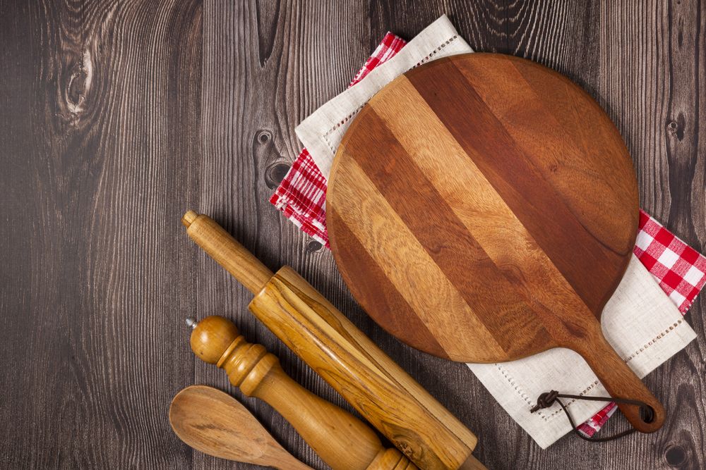 Empty pizza board on rustic wooden table. Top view image.