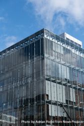 Glass facade of building against a blue sky with light clouds 5kymob