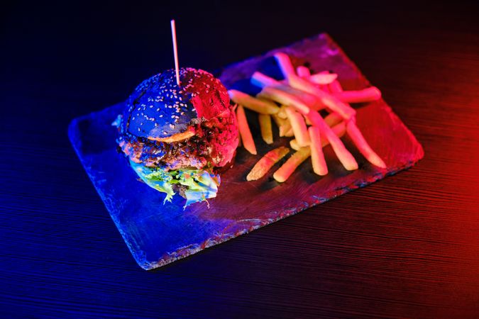 Delicious hamburger and fried potato on board
