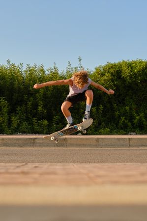 Energetic skater jumping with skateboard