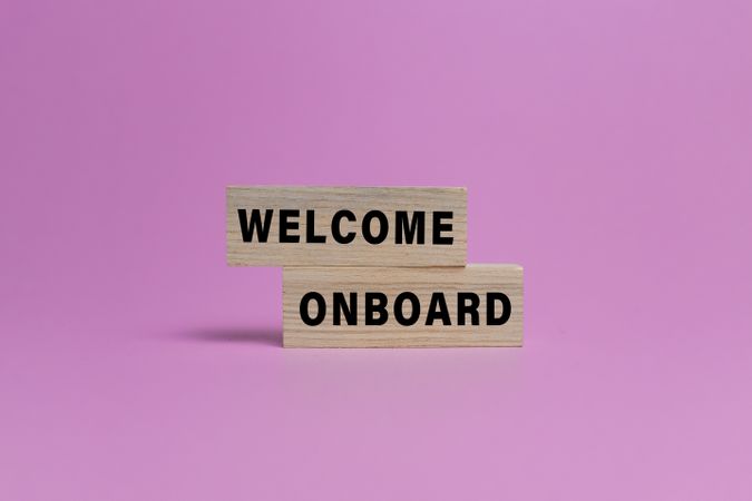 welcome onboard word text on wooden blocks isolated on pink background