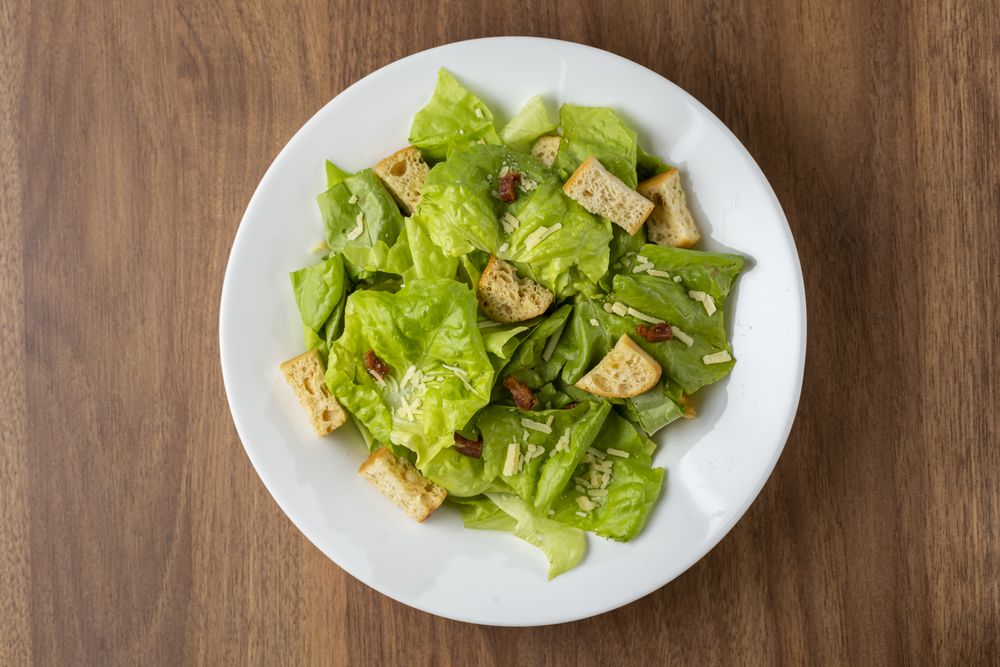 Caesar salad with croutons and bacon.
