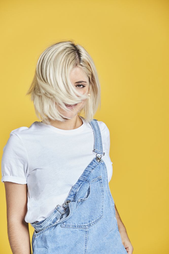 Trendy blonde female in denim sundress
