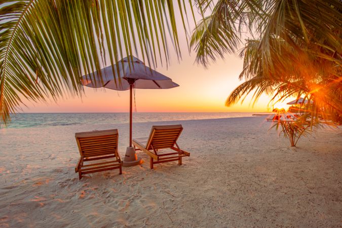 Lounge chairs on the beach at sunset