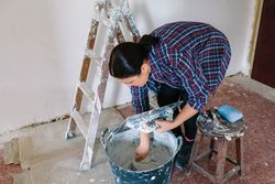 Mason working picking plaster with spatula