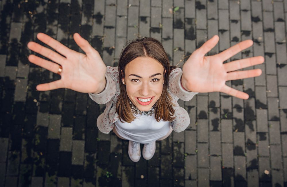 Happy young women with hands up at camera