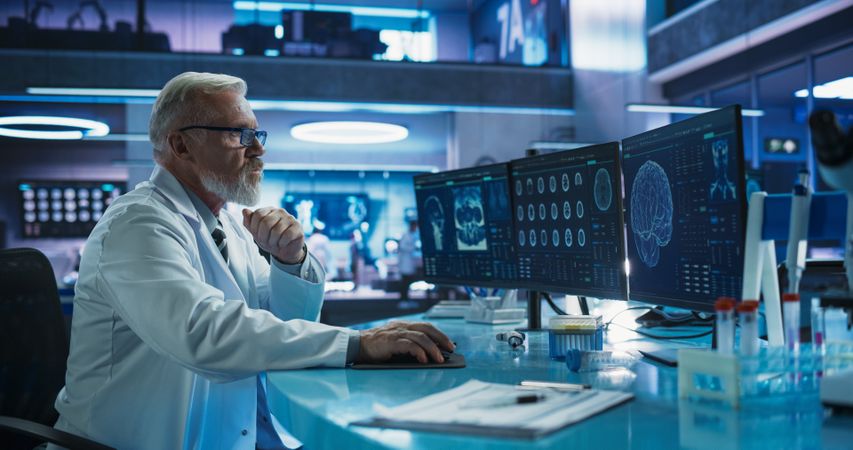 Surgeon Studying CT Scan Of Patient Suffering From Brain Tumor.