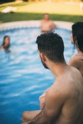 Friends sitting on edge of pool