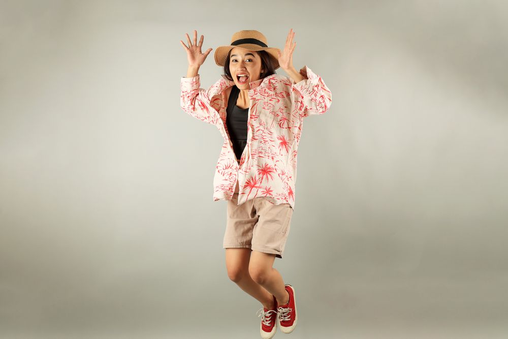 Young Asian Tourist Woman Smiling to the Camera and Jumping, Overjoy About Summer Vacation.