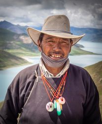 Tibet - August, 29 2014: Tibetan man near river and hills