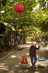 Carrying wares through old town in Hoi An Vietnam