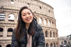 Cheerful Asian traveler outside famous landmark