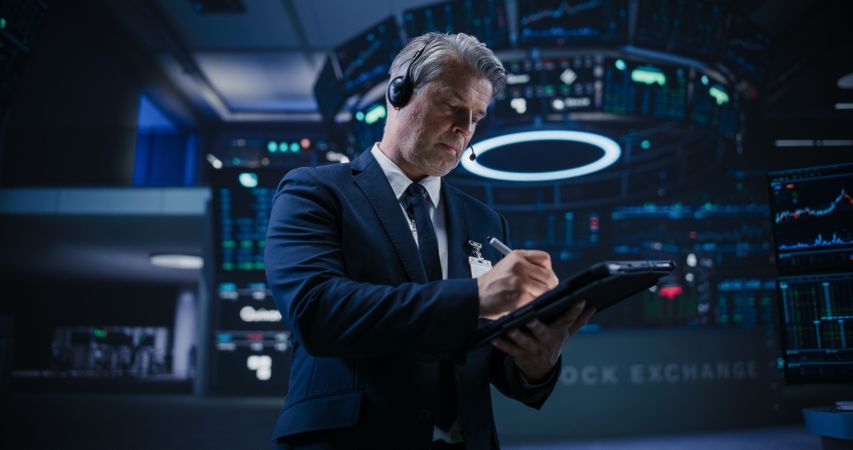 Talented Stock Exchange Investor Working on a Tablet Computer, Day Trading Company Shares, Valuable Technology Investments, Public and Private Securities.