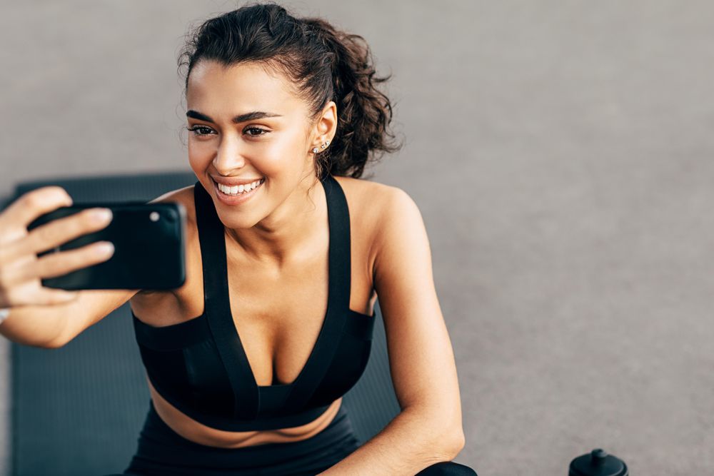 Smiling woman taking a selfie before a workout