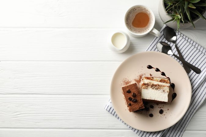 Composition with tasty tiramisu and cocoa drink on blank wooden table. Delicious dessert