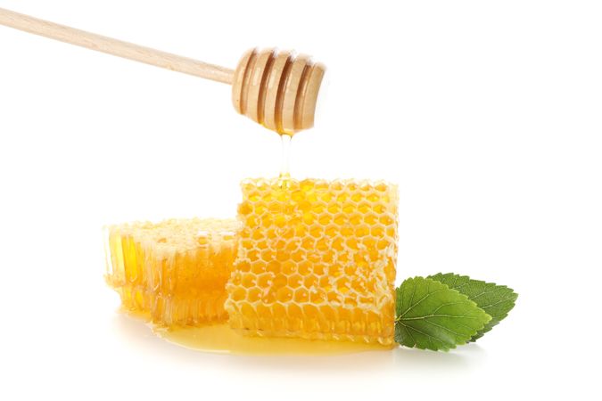 Honeycombs, dipper and leaves isolated on blank background
